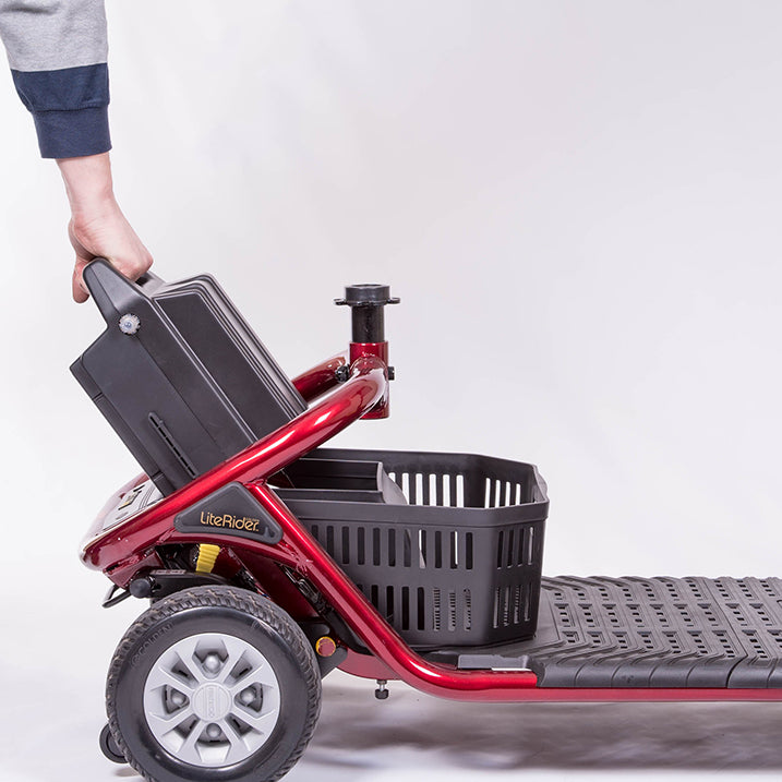 Red mobility scooter with a black basket and suitcase on a white background