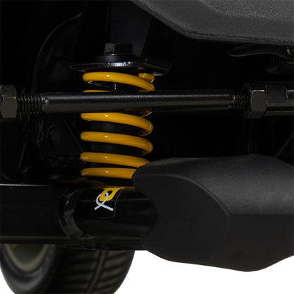 Close-up of a vehicle suspension system with yellow springs and a black shock absorber.