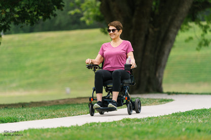 Woman using a mobility scooter in a park setting