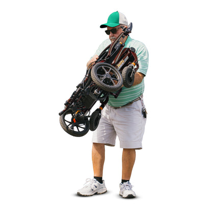 Man holding a folded electric wheelchair on a white background