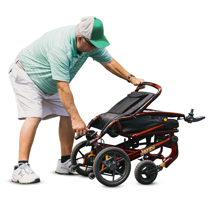 Man adjusting a folded electric wheelchair on a white background