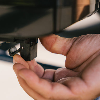 Close-up of a hand holding a small black electronic device.