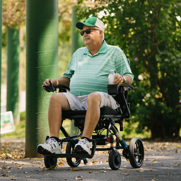 Man in a green shirt and cap using a Jazzy carbon HD 